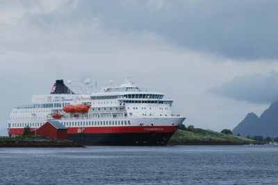 Eines der Hurtigrute-Schiffe. Hier läuft es gerade zwischen zwei Inseln in den Hafen von Brönnöysund ein und wird anschliessend das Loch im Berg Torghatten besuchen.